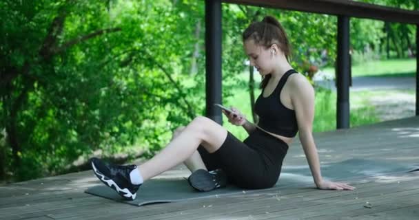 Mulher bonita usando smartphone após o treino — Vídeo de Stock