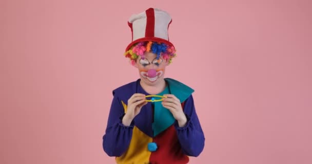 Смішний клоун вибирає різнокольорові окуляри — стокове відео