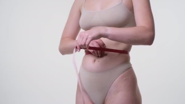 Измерительная талия женщины с помощью ленты — стоковое видео