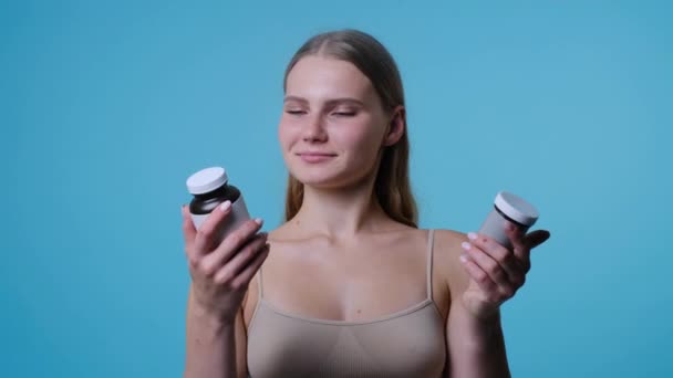 Jonge blanke vrouw op zoek naar vitamine pillen — Stockvideo