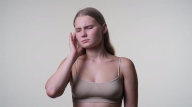 Genç sarışın kadın baş ağrısı çekiyor.