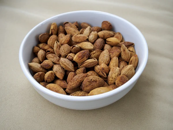 Bowl of almonds on canvas — Stock Photo, Image