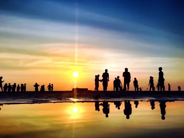 Gün batımında faaliyetlerdir sahilde Silhouettes