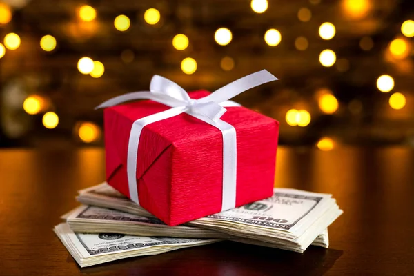 背景にぼやけたライト上の米国100ドル札の赤いギフトボックス 米ドルだ クリスマスと新年のお金が存在します 贈り物代だ １００ 金融とビジネスの概念 クリスマスショッピング — ストック写真