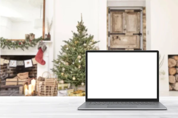 冬の販売 休日のオンラインショッピング 空のディスプレイ画面ラップトップコンピュータ クリスマスの装飾が施されたモダンな居心地の良い家庭のリビングルーム ホームオフィスのデスクワークスペース コピースペースをモックアップします オンラインストア 電子商取引 ストック写真