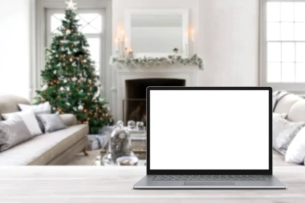 冬の販売 休日のオンラインショッピング 空のディスプレイ画面ラップトップコンピュータ クリスマスの装飾が施されたモダンな居心地の良い家庭のリビングルーム ホームオフィスのデスクワークスペース コピースペースをモックアップします オンラインストア 電子商取引 ロイヤリティフリーのストック写真
