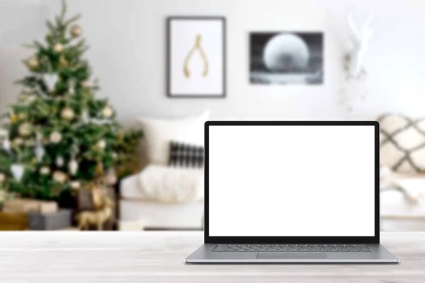 冬の販売 休日のオンラインショッピング 空のディスプレイ画面ラップトップコンピュータ クリスマスの装飾が施されたモダンな居心地の良い家庭のリビングルーム ホームオフィスのデスクワークスペース コピースペースをモックアップします オンラインストア 電子商取引 ロイヤリティフリーのストック画像