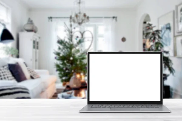 冬の販売 休日のオンラインショッピング 空のディスプレイ画面ラップトップコンピュータ クリスマスの装飾が施されたモダンな居心地の良い家庭のリビングルーム ホームオフィスのデスクワークスペース コピースペースをモックアップします オンラインストア 電子商取引 ストックフォト