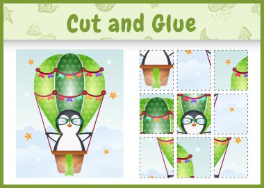 Çocukların masa oyunu, sıcak hava balonunda şirin bir penguenle kes ve yapıştır.