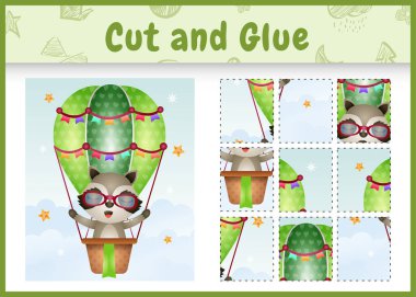 Çocuk masa oyunu, sıcak hava balonunda şirin bir rakunla kes ve yapıştır.