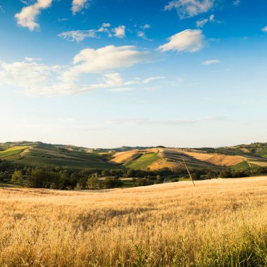 İlkbaharda kırsal alan, tepeler ve bulutlu mavi gökyüzü