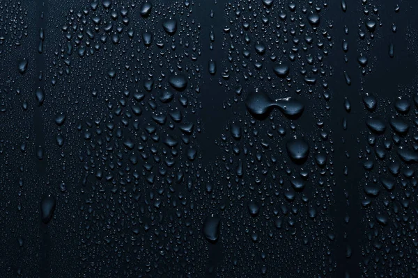Pürüzsüz yüzeydeki su damlalarını kapat, mavi arkaplan