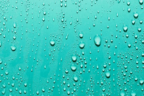 Pürüzsüz yüzeydeki su damlalarını kapat, mavi arkaplan
