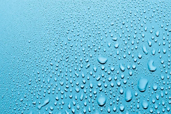 Pürüzsüz yüzeydeki su damlalarını kapat, mavi arkaplan