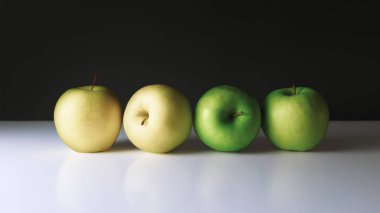 Durgun bir hayat, olgun elmalar yakın, karanlık bir arka plan.