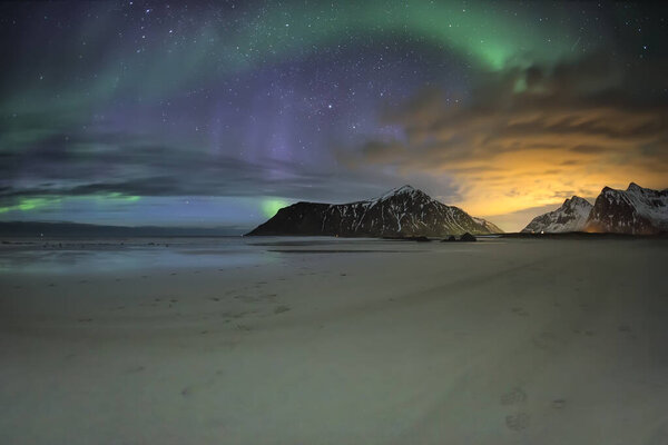 aurora boreal desde la playa con una montaa