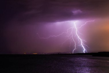 İspanya, Formentera 'da gece vakti gök gürültülü bir fırtınada ufka çarpan yıldırım.