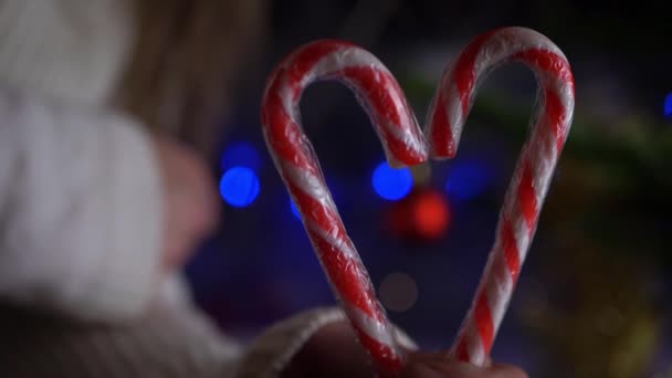 Manos sosteniendo el corazón de amor hecho de bastón de caramelo — Vídeo de stock