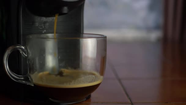 Verse koffie die uit een koffiezetapparaat in een glazen mok stroomt — Stockvideo