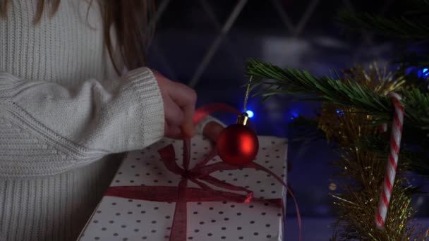 Frau öffnet Geschenk unter dem Weihnachtsbaum — Stockvideo