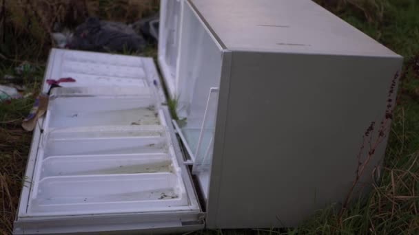 Холодильник сброшен в сельской местности поле изолированный выстрел — стоковое видео