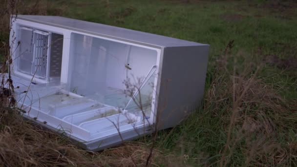 Refrigerator dumped in countryside field medium shot — Stock Video