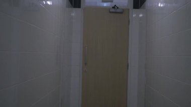 Kapı çıkışına doğru dar koridor boyunca ilerliyoruz.