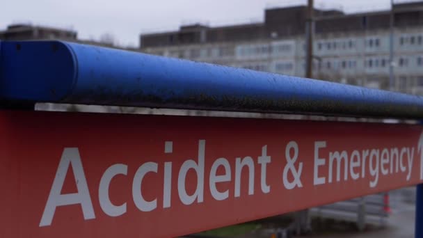Značka nehody a pohotovosti s britskou nemocnicí NHS v pozadí — Stock video
