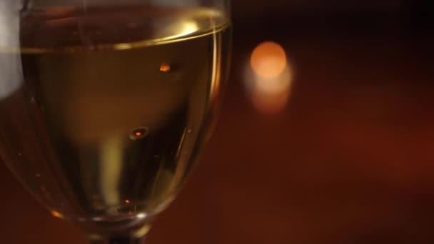 Glas av vitt vin med bokeh ljus — Stockvideo