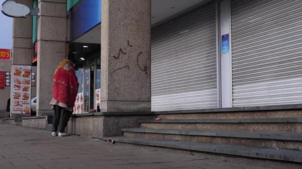 Hemlös man i city street insvept i filt bred skott — Stockvideo