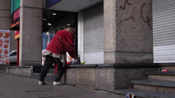 Hemlös man i stadsmiljö samlar tillhörigheter — Stockvideo