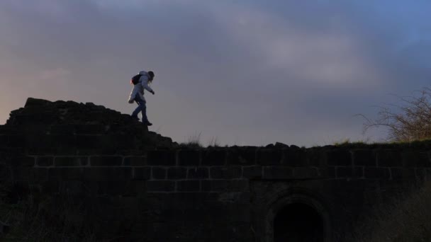 Žena turistka lezení na drsné skalnaté krajině — Stock video