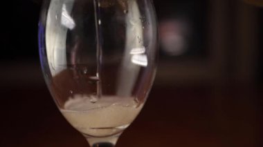 Beyaz şarap bardağa dökülüyor.