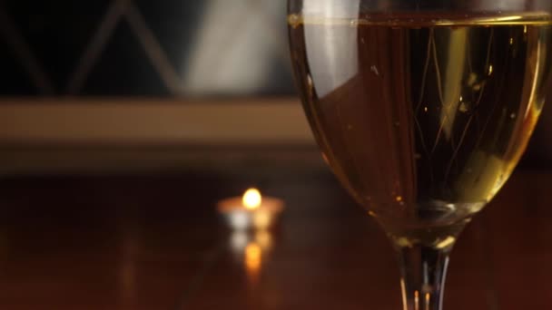 キャンドルを背景に白ワインのグラス — ストック動画