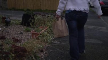 Kese kağıdında yemek taşıyan bir kadın. 