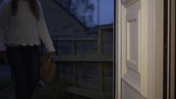 La mujer camina a la puerta de la casa con comida para llevar — Vídeos de Stock