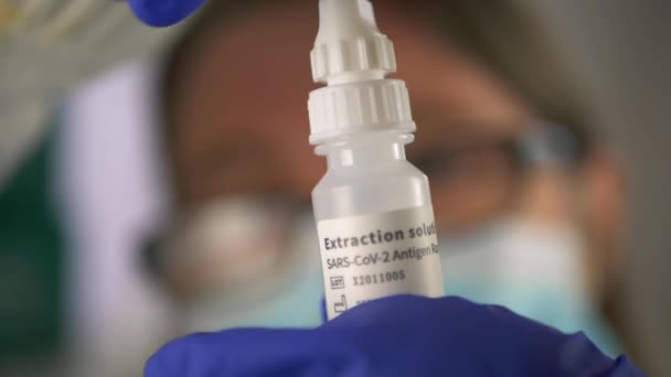 Medisch personeel openen fles van Covid testen extractie vloeistof — Stockvideo