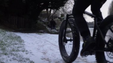 Kar yağışı sonrası kanal yamaçlarında yüksek çözünürlüklü ceketli bisikletçi.
