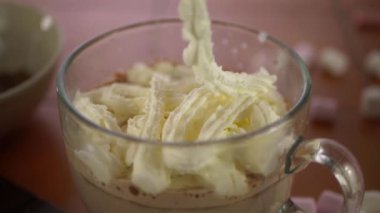 Bir bardak sıcak çikolataya taze krema servis ediyorum.