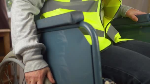 Rullstolsanvändare anställd bär hi-vis jacka — Stockvideo