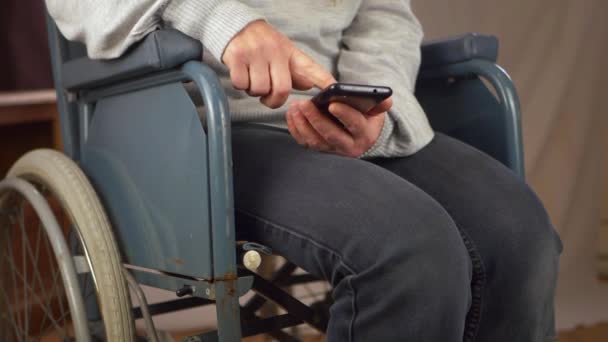 Usuarios de sillas de ruedas desplazándose en el teléfono celular — Vídeos de Stock