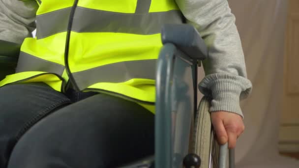 Rullstolsanvändare anställd bär hi-vis jacka — Stockvideo