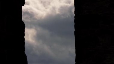 Eerie storm clouds timelapse through view of building ruins