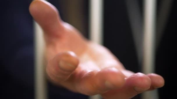 Prisionero extendido mano desde detrás de las rejas de la prisión — Vídeos de Stock