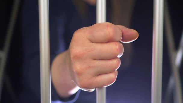 Main d'un prisonnier sur des barreaux de cellules — Video