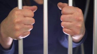 Hücre parmaklıklarında tutuklu elleri
