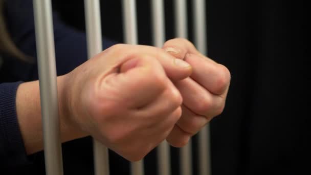 Odsouzený ruce v pěst zpoza vězení mříží — Stock video