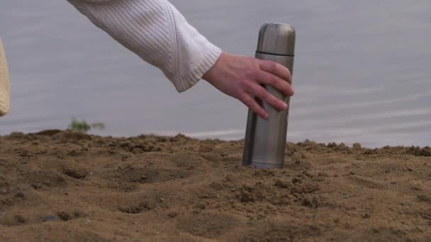 Mãos com chapéu de palha e garrafa térmica na praia — Vídeo de Stock