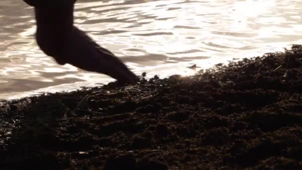 Рука играет с водой на закате — стоковое видео