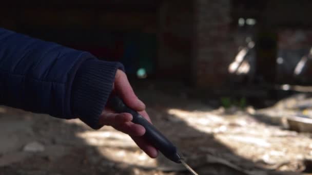 Criminal juega con cuchillo en las sombras de un edificio abandonado — Vídeos de Stock
